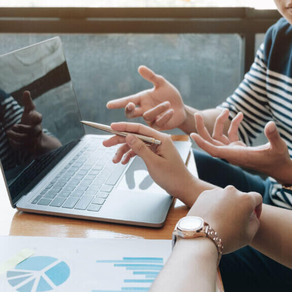 Businessman holding pens and holding graph paper are meeting to plan sales to meet targets set in next year.